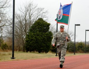 U.S. Air Force Staff Sgt. Alexander Gabrielse, 1st Maintenance Squadron armament shop technician, carries the Tactical Air Control Party flag during a 24-hour vigil at Joint Base Langley-Eustis, Va., March 25 and 26, 2015. Gabrielse, who has family members that are still active in the Special Operations field, walked a total of 17 laps. (U.S. Air Force photo by Senior Airman Breonna Veal/Released)