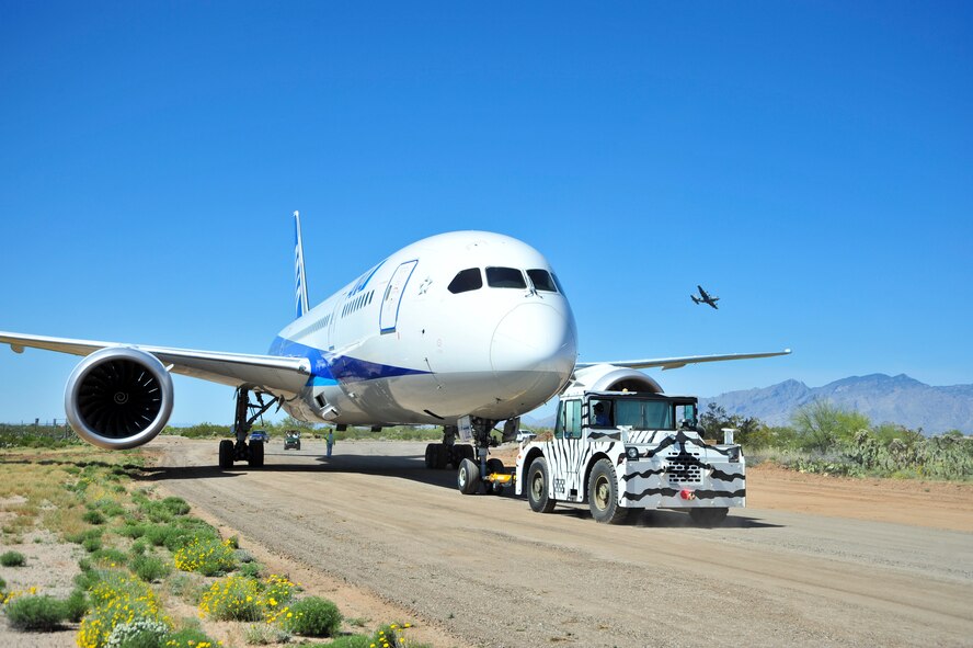 A Boeing 787-8 Dreamliner is towed on a newly widened road to Pima Air & Space Museum after landing and defueling at Davis-Monthan Air Force Base, Ariz., March 26, 2015.  The 355th Civil Engineer Squadron used this opportunity to conduct training on creating and paving roads; skills which are necessary to have in deployed locations.   (U.S. Air Force photo by Airman 1st Class Chris Massey/Released)