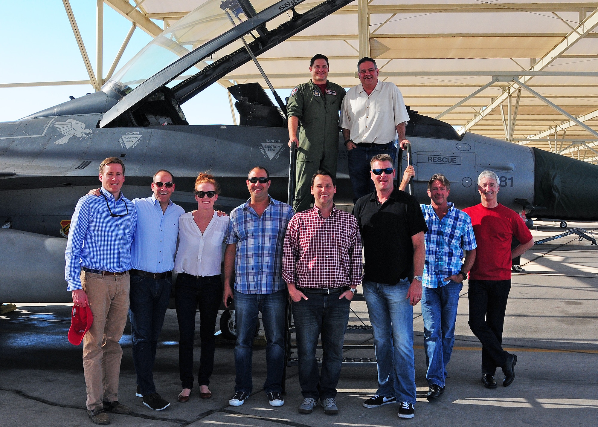 Local business owners pose with Maj. Skyler Hester, 69th Fighter Squadron instructor pilot, next to an F-16 March 27 during the Entrepreneurs Organization tour at Luke Air Force base, Ariz. (U.S. Air Force photo taken by Tech. Sgt. Louis Vega Jr.)