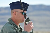 HILL AIR FORCE BASE, Utah – Air Force Reserve Lt. Col. Karl Haagsma, 910th Aerial Spray Flight Entomologist based at Youngstown Air Reserve Station, Ohio, talks on a radio while standing on an access road to a target site on the Utah Test and Training Range near here, March 18, 2015. Haagsma is communicating with an aircrew aboard a 910th C-130H Hercules aircraft preparing to spray an herbicide over selected areas of the range to eliminate an unwanted ground covering weed obscuring target sites and hindering Explosive Ordinance Disposal (EOD) operations. The 910th Airlift Wing is home to the Department of Defense’s only large area, fixed wing aerial spray capability. U.S. Air Force photo by Master Sgt. Bob Barko Jr.