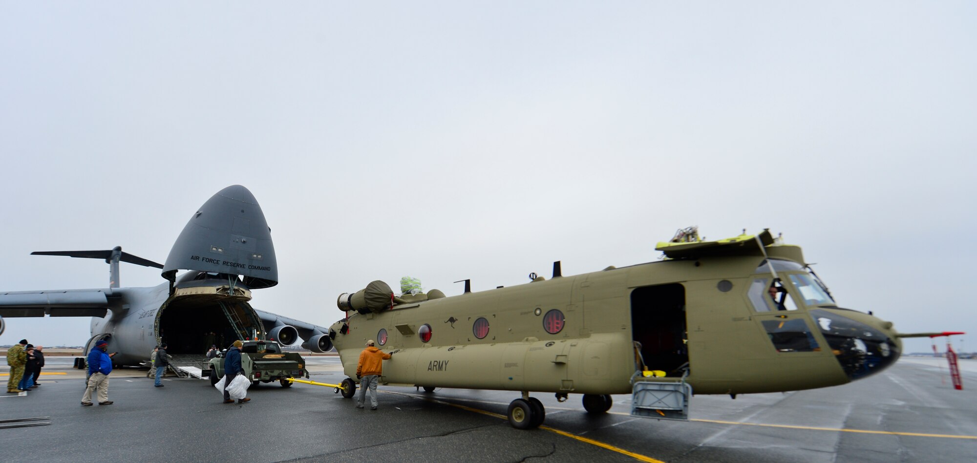 A Chinook CH-47F helicopter is prepared for loading into a C-5B Galaxy from the 439th Airlift Wing, Westover Air Reserve Base, Mass., March 27, 2015, at Dover Air Force Base, Del. Two chinook helicopters were loaded into the C-5B Galaxy weighing 24,000 pounds each and will be transported to the Australian Army. (U.S. Air Force photo/Airman 1st Class William Johnson)