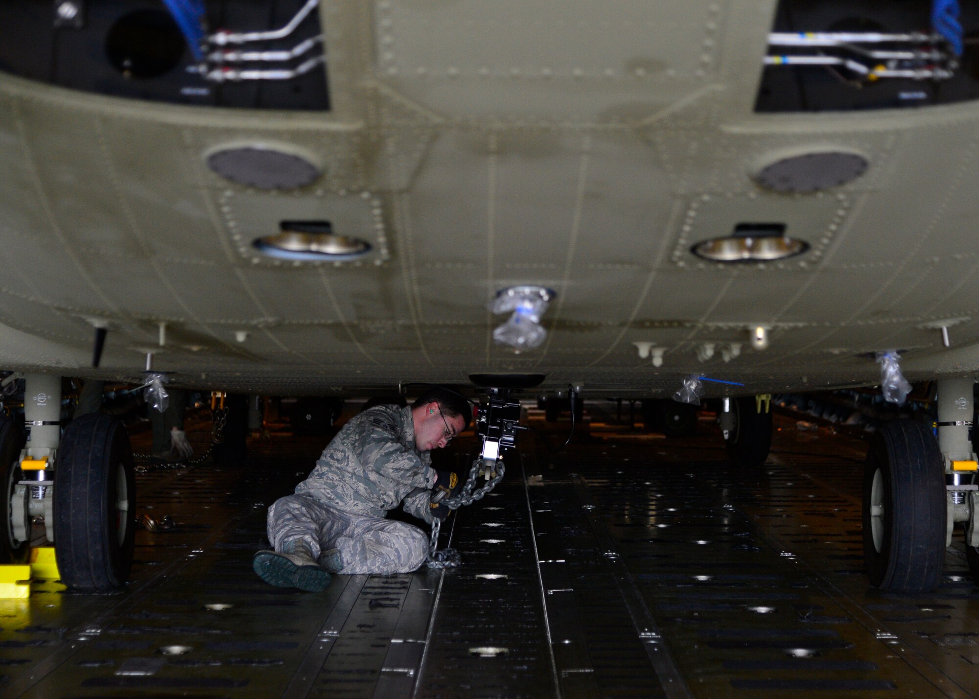 Senior Airman Ronell Rosa, 436th Aerial Port Squadron, attaches chains to a Chinook CH-47F helicopter inside of C-5B Galaxy from the 439th Airlift Wing, Westover Air Reserve Base, Mass., March 27, 2015, at Dover Air Force Base, Del. Team Dover assisted members of Westover ARB’s 337th Airlift Squadron in loading two Chinook helicopters bound for the Australian Army. (U.S. Air Force photo/Airman 1st Class William Johnson)
