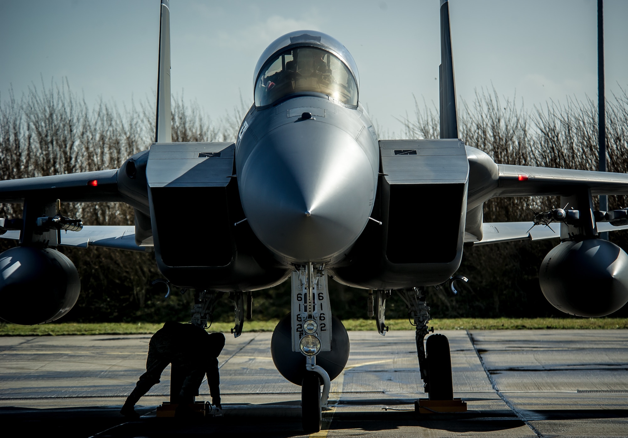 A crew chief from the 125th Fighter Wing, Jacksonville, Fla. sets chocks by the wheels of an F-15C Eagle at Leeuwarden Air Base, Netherlands, March 31, 2015. F-15C Eagles from the Florida Air National Guard's 159th Expeditionary Fighter Squadron are deployed to Europe as the first ever ANG theater security package here. These F-15s will conduct training alongside our NATO allies to strengthen interoperability and to demonstrate U.S. commitment to the security and stability of Europe. (U.S. Air Force photo/ Staff Sgt. Ryan Crane)