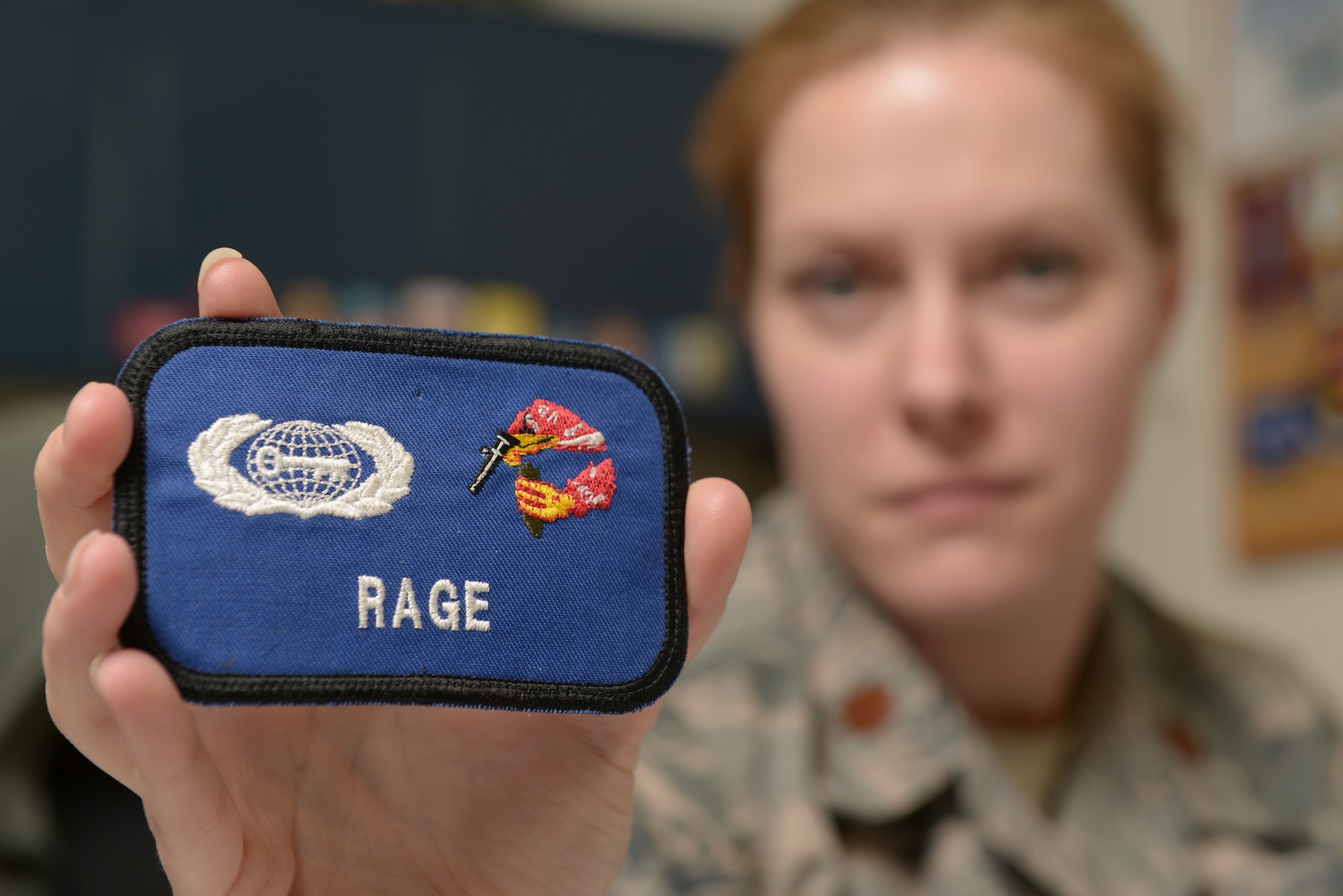 U.S. Air Force Maj. Victoria Williams, the 354th Fighter Wing senior intelligence officer, displays one of her unit patches at Eielson Air Force Base, Alaska, March 26, 2015. Williams advises the wing commander and senior leaders on any threats to their forces at home or deployed and manages intelligence professionals assigned to the wing. (U.S. Air Force photo by Senior Airman Peter Reft/Released)¬¬¬¬