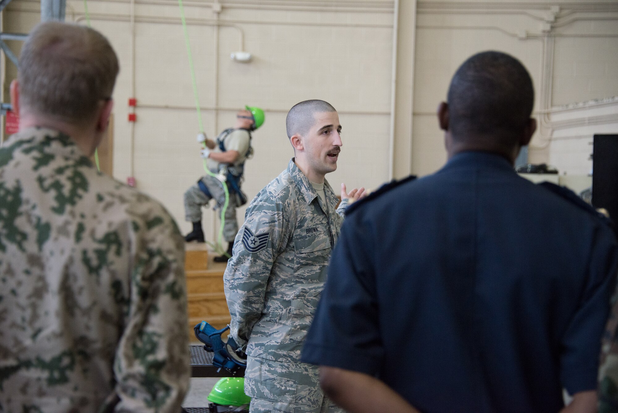 Tech. Sgt. Keith Brown, 338th Training Squadron instructor, briefs members of the International Air Attaché on equipment and safety specifics during a tower climbing demo seen in the background March 25, 2015, at Keesler Air Force Base, Miss. The purpose of the visit was to provide these diplomatically accredited international attachés with a view of military, industrial, cultural and social aspects of the United States and facilitate the development of cordial relations. (U.S. Air Force photo by Marie Floyd)