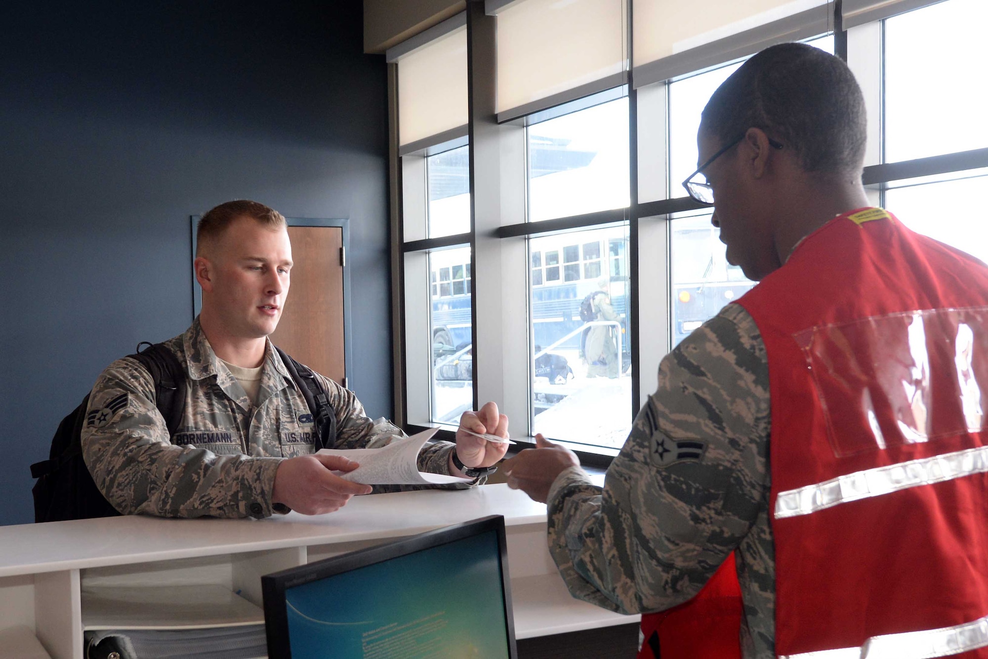 Senior Airman Chezz Bornemann, 28th Maintenance Squadron crew chief, processes through a deployment line assisted by Airman 1st Class Daquanne McDowell, 28th Force Support Squadron force management technician, prior to leaving for Red Flag 15-2 at the Deployment Center at Ellsworth Air Force Base, S.D., Feb. 26, 2015. Nearly 100 maintainers and aviators departed for Nellis Air Force Base, Nev., to take part in a joint training exercise designed to increase the combat capability of U.S. and allied forces for future military conflicts. (U.S. Air Force photo by Airman 1st Class Rebecca Imwalle/Released)