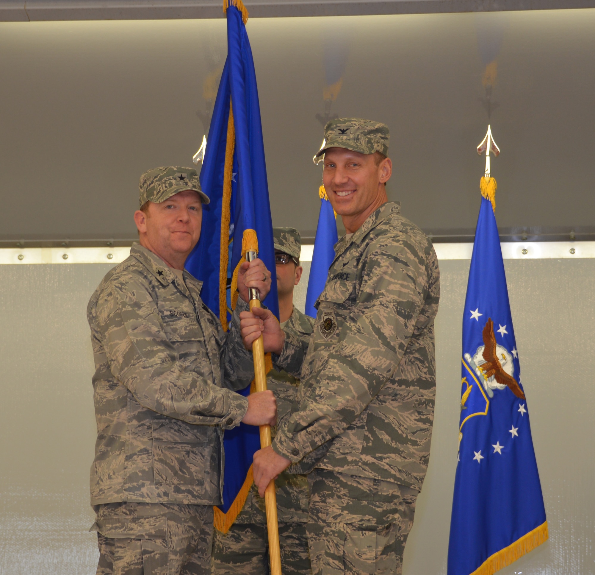 Brig. Gen. Richard Scobee, 10th Air Force Commander, presents the 477th Fighter Group colors to Col. David Piffarerio, the new 477th Fighter Group Commander, Friday, Mar. 20, 2015, at the 477th Fighter Group Change of Command Ceremony in Hangar 25. (US Air Force photo by Tech. Sgt. Dana Rosso)