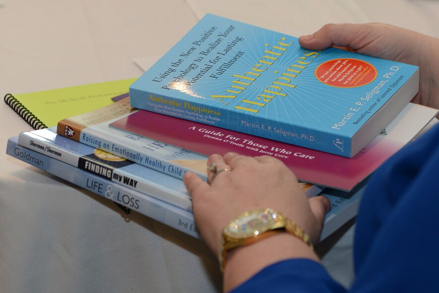 A participant shuffles through reading material during the Living in the New Normal Institute March 25, 2015, at a hotel in Valdosta, Ga. The material consisted of books to help and support children through life lessons such as grief and self-esteem building. (U.S. Air Force photo by Airman 1st Class Kathleen D. Bryant)