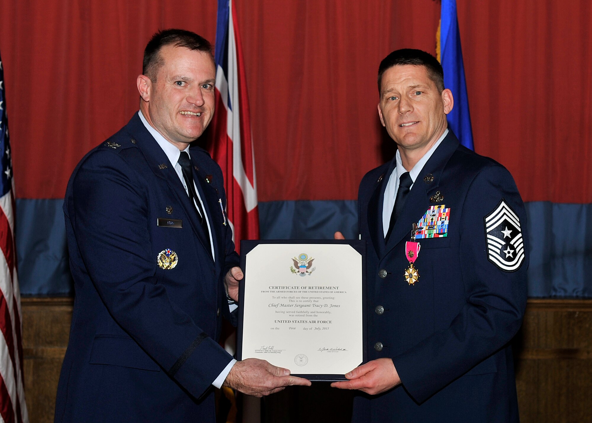 U.S. Air Force Col. Kenneth T. Bibb, Jr., 100th Air Refueling Wing commander, presents a certificate of retirement to Chief Master Sgt. Tracy Jones, 100th ARW command chief March 30, 2015, on RAF Mildenhall, England. Chief Jones retired after dedicating 28 years of service to the Air Force. (U.S. Air Force photo by Airman 1st Class Kyla Gifford/Released)
