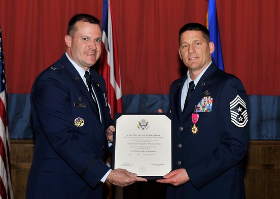 U.S. Air Force Col. Kenneth T. Bibb, Jr., 100th Air Refueling Wing commander, presents a certificate of retirement to Chief Master Sgt. Tracy Jones, 100th ARW command chief March 30, 2015, on RAF Mildenhall, England. Chief Jones retired after dedicating 28 years of service to the Air Force. (U.S. Air Force photo by Airman 1st Class Kyla Gifford/Released)
