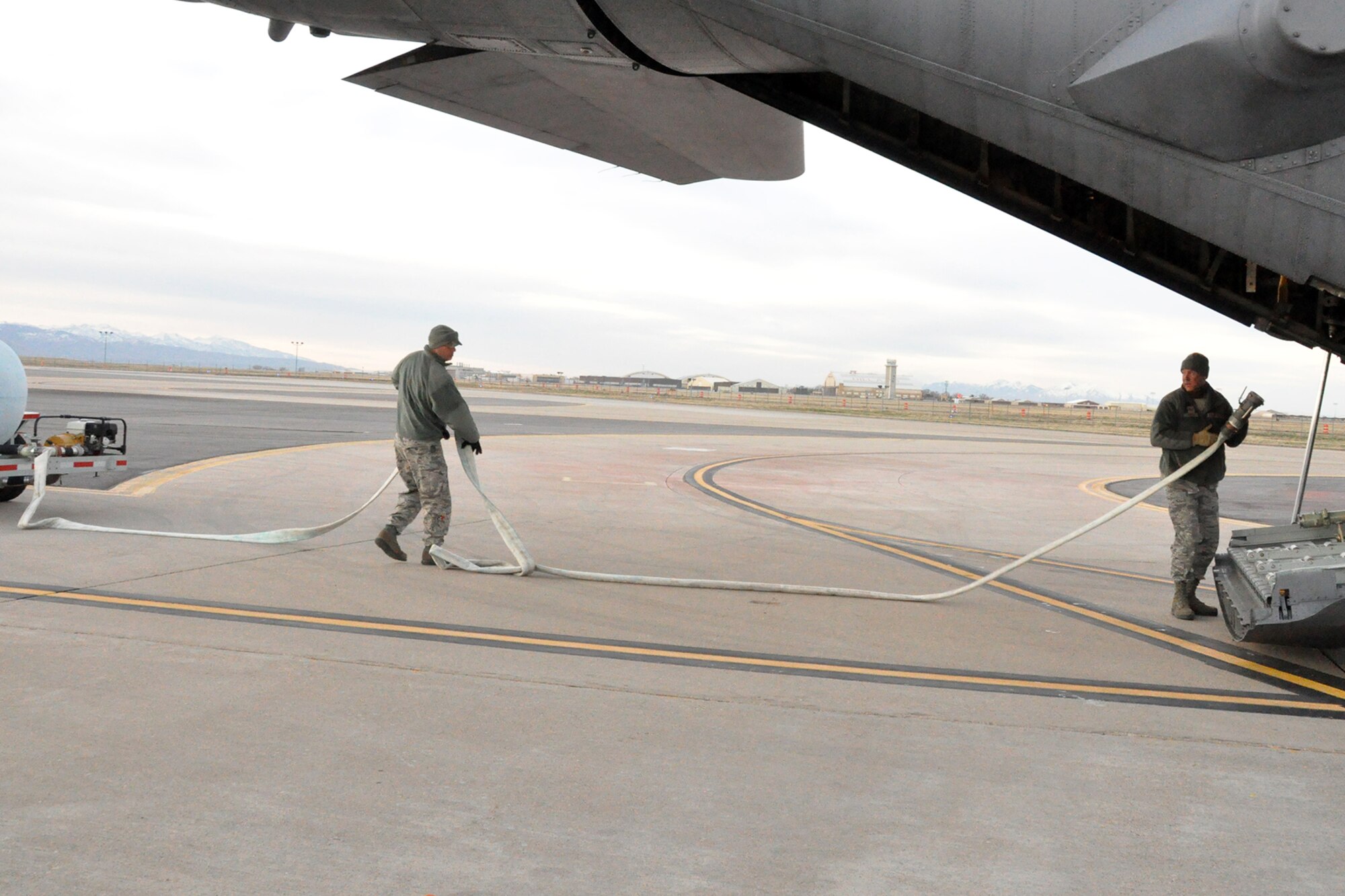HILL AIR FORCE BASE, Utah – Air Force Reserve Tech. Sgt. Jeremy Rogers and Tech. Sgt. Tom Kocis, both 910th Airlift Wing Aerial Spray Maintainers, carry a hose to the rear of a modified C-130H Hercules tactical cargo aircraft, assigned to the 910th based at Youngstown Air Reserve Station, Ohio, on the flightline here in preparation for an aerial spray sortie, March 17, 2015. Rogers, Kocis and other members of the 910th’s Aerial Spray Maintenance Flight are loading the aircraft, outfitted with a Modular Aerial Spray System (MASS), with a herbicide which was sprayed over the nearby Utah Test and Training Range (UTTR), eliminating unwanted ground covering weeds which can obscure target sites and Unexploded Ordinance (UXO) on bombing ranges. The 910th Airlift Wing is home to the Department of Defense’s (DoD) only large-area fixed wing aerial spray capability and dedicated aerial spray maintenance flight. U.S. Air Force photo by Senior Airman Rachel Kocin