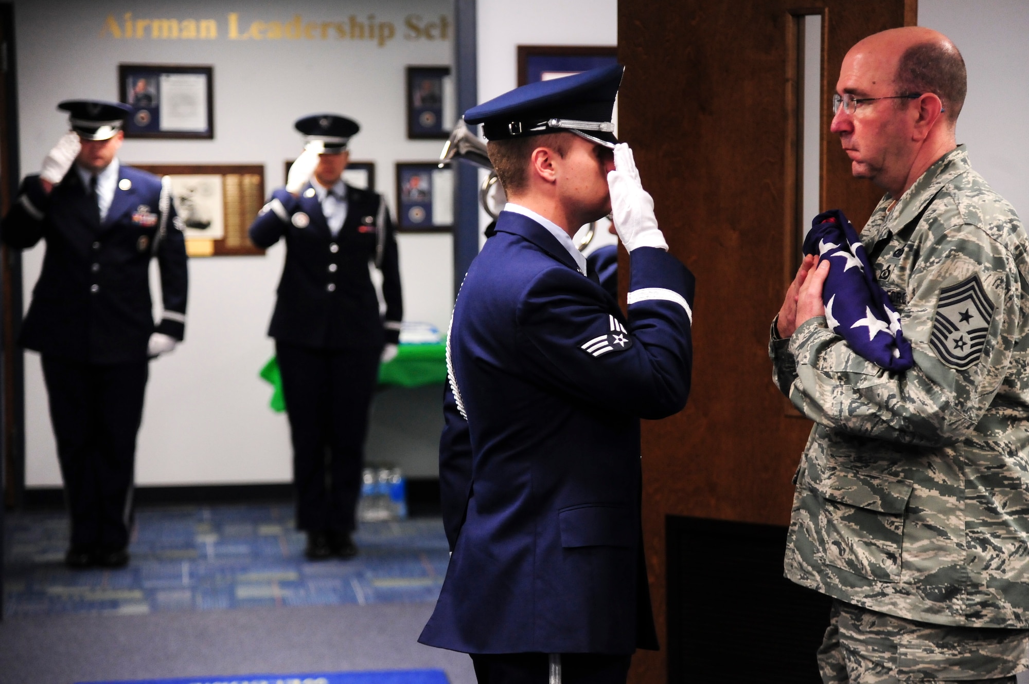 Members of the 4th Fighter Wing Honor Guard salute and present a flag to Chief Master Sgt. Jeffrey Craver, 4th Fighter Wing command chief, during a remembrance ceremony for retired Chief Master Sgt. of the Air Force James C. Binnicker, the ninth CMSAF, March 27, 2015, at Seymour Johnson Air Force Base, North Carolina. Before he achieved the highest enlisted rank in the Air Force, Binnicker served at Seymour Johnson AFB as the base sergeant major and the senior enlisted advisor. (U.S. Air Force photo/Senior Airman Brittain Crolley)