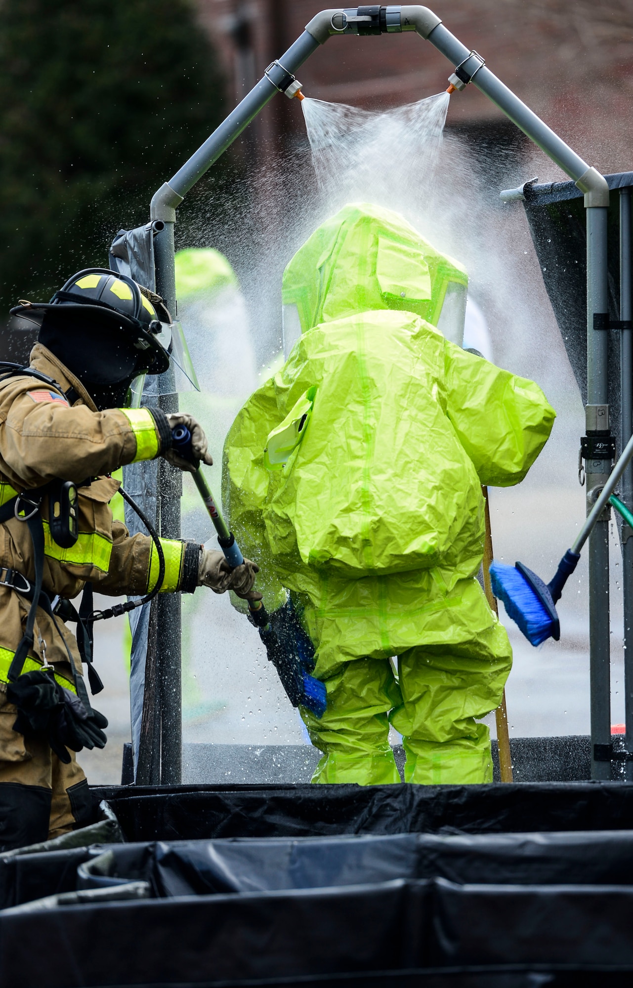 A U.S. Air Force Airman goes through a decontamination station during a simulated chemical, biological, radiological, nuclear and high-yield explosive threat exercise at Langley Air Force Base, Va., March 26, 2015. Emergency responders were tasked with safely evacuating personnel, setting up a decontamination station, entering a contaminated zone and mitigating a possible threat. (U.S. Air Force photo by Senior Airman Kayla Newman/Released)