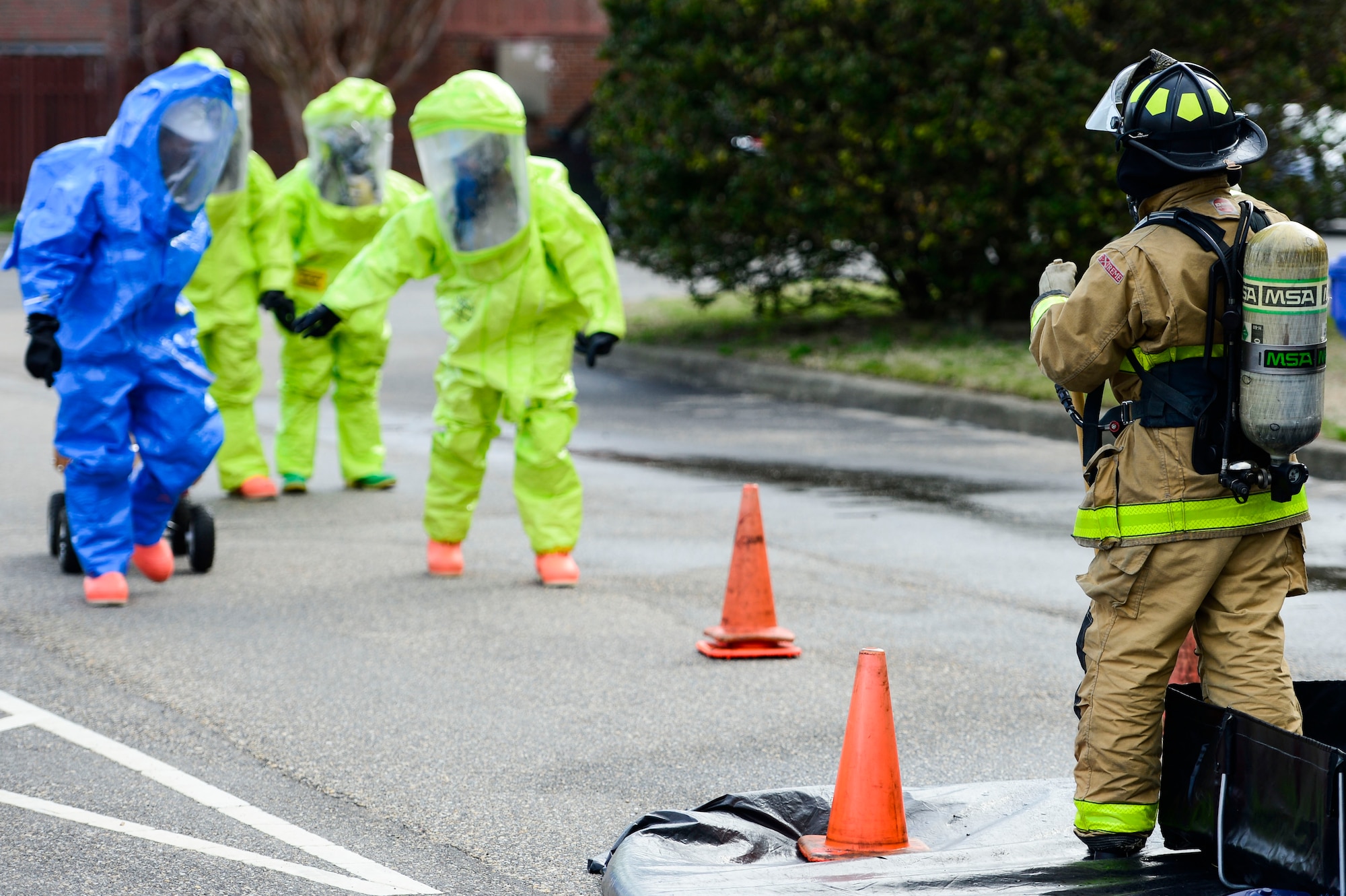 U.S. Air Force Airmen prepare to enter a decontamination zone during a simulated chemical, biological, radiological, nuclear and high-yield explosive threat exercise at Langley Air Force Base, Va., March 26, 2015. Airmen participating in the exercise demonstrated the proper steps in responding to a CBRNE threat. (U.S. Air Force photo by Senior Airman Kayla Newman/Released)