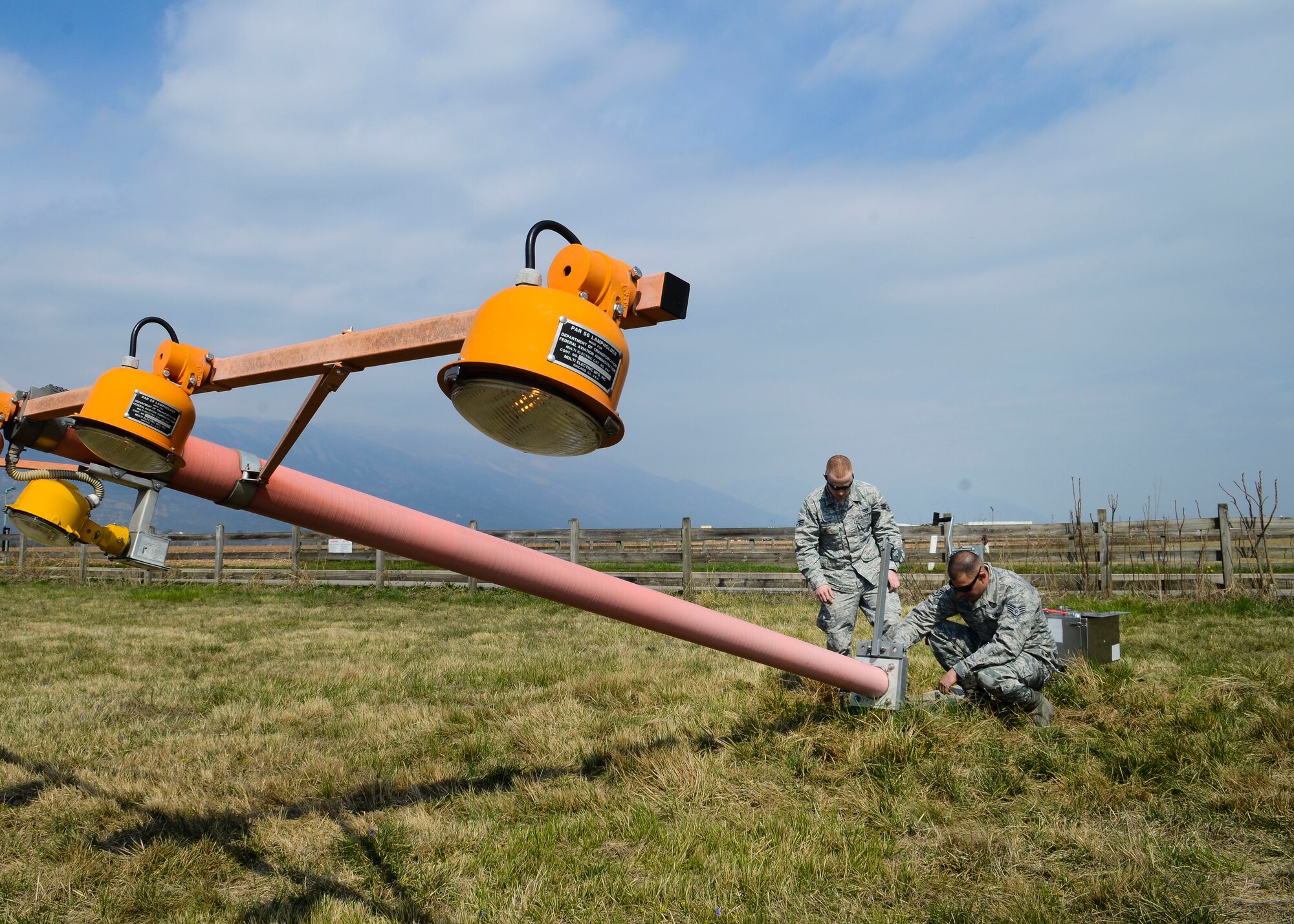 U.S. Air Force Senior Airman Zac Rathbun, 31st Civil Engineer Squadron electrical systems journeyman and Staff Sgt. Anthony Gomez, 31st CES electrical systems craftsman, repair torn electrical lines for a runway light, March 30, 2015, at Aviano Air Base, Italy. The 31 CES electrical systems section manages lightning protection systems, base lighting and other electrical systems. (U.S. Air Force photo by Senior Airman Austin Harvill/Released)