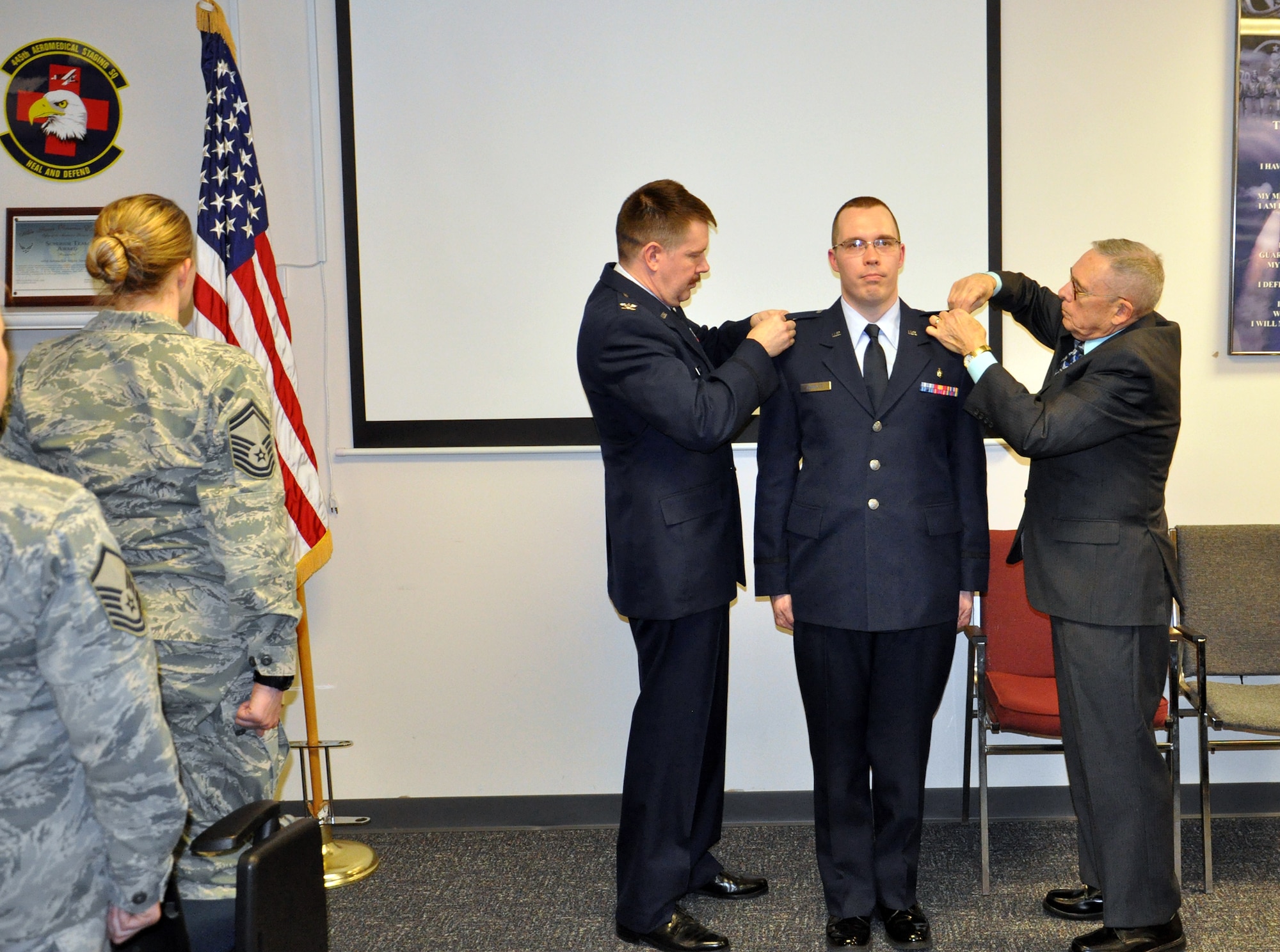 WRIGHT-PATTERSON AIR FORCE BASE, Ohio – Col. Jeffrey S. Beery, 445th Aeromedical Staging Squadron commander and Tom Charles, father of 2nd Lt. Jonathan D. Charles pin on second lieutenant bars during Jonathan's promotion ceremony March 21, 2015.. Tech. Sgt. Jonathan D. Charles was commissioned as a second lieutenant in the Medical Service Corps. Charles will remain a member of the squadron where his hard work and dedication is truly appreciated. (U.S. Air Force photo/Maj. Demetrius Smith)