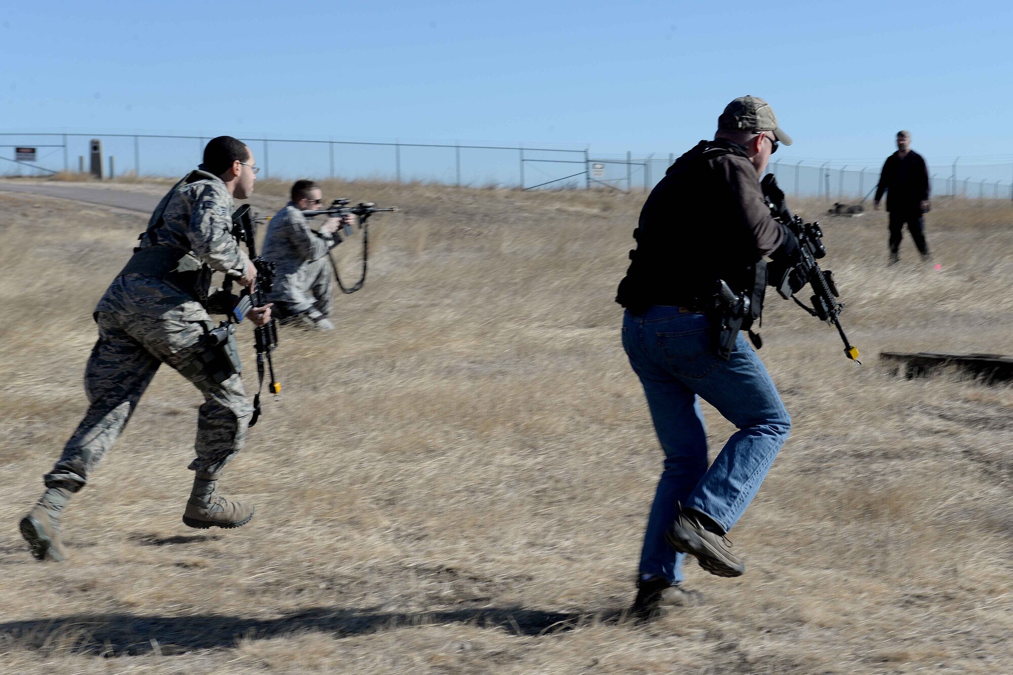 Senior Airman Deandre Smith, 28th Security Forces Squadron response force leader (left) and John Kost, 28th SFS flight chief, participate in shoot- move-communicate training at Ellsworth Air Force Base, S.D., March 10, 2015. This training teaches Airmen how to effectively engage their target, communicate and protect each other in combat situations. (U.S. Air Force photo by Airman 1st Class Rebecca Imwalle/Released)