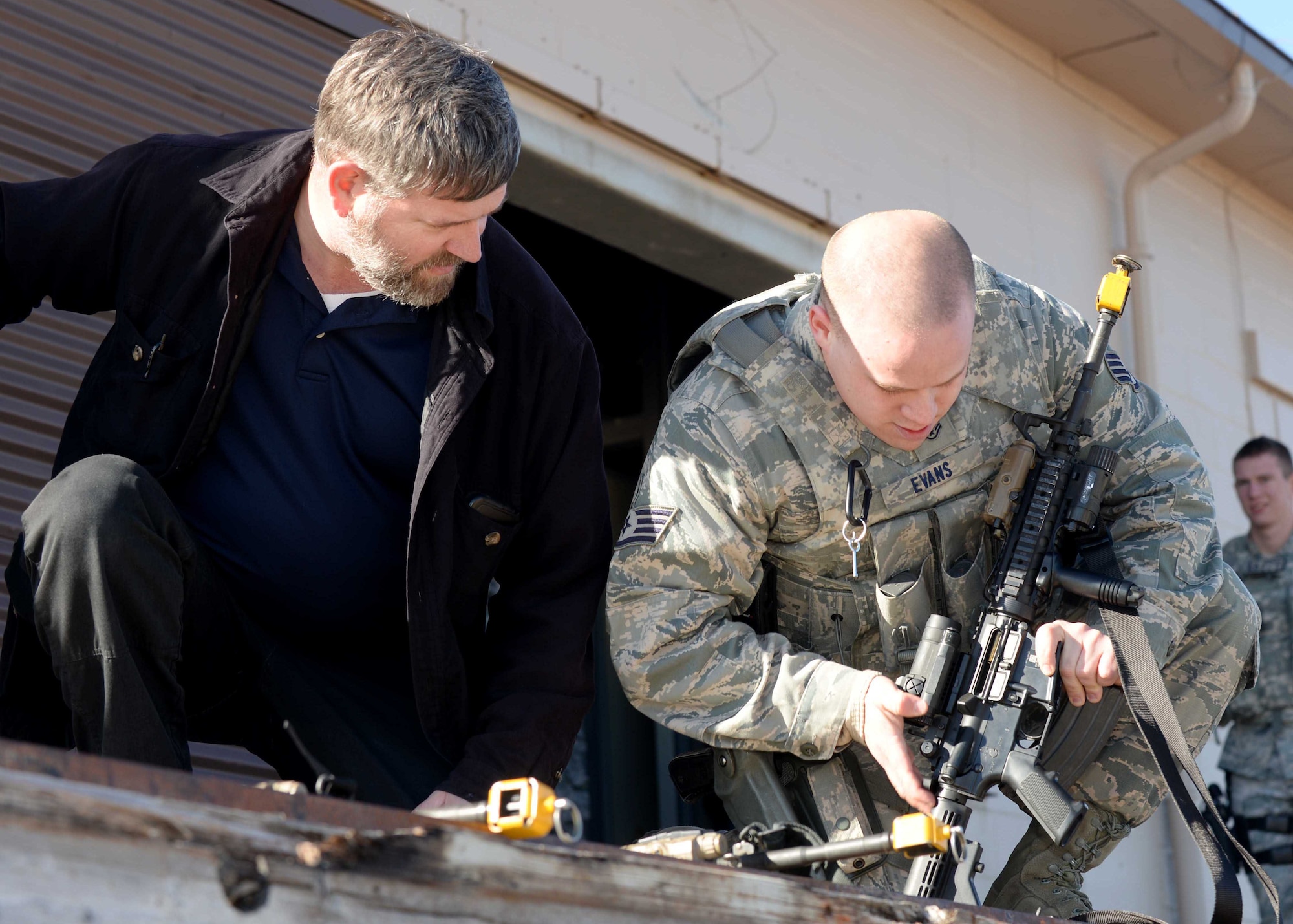 Dion Harris, 28th Security Forces Squadron lead instructor (left), evaluates Staff Sgt. Tylor Evans, 28th SFS response force leader, as he troubleshoots a malfunction in his M4 rifle during a training session at Ellsworth Air Force Base, S.D., March 10, 2015. During the training, Airmen were evaluated on how they dealt with weapon malfunctions under stress. (U.S. Air Force photo by Airman 1st Class Rebecca Imwalle/Released)