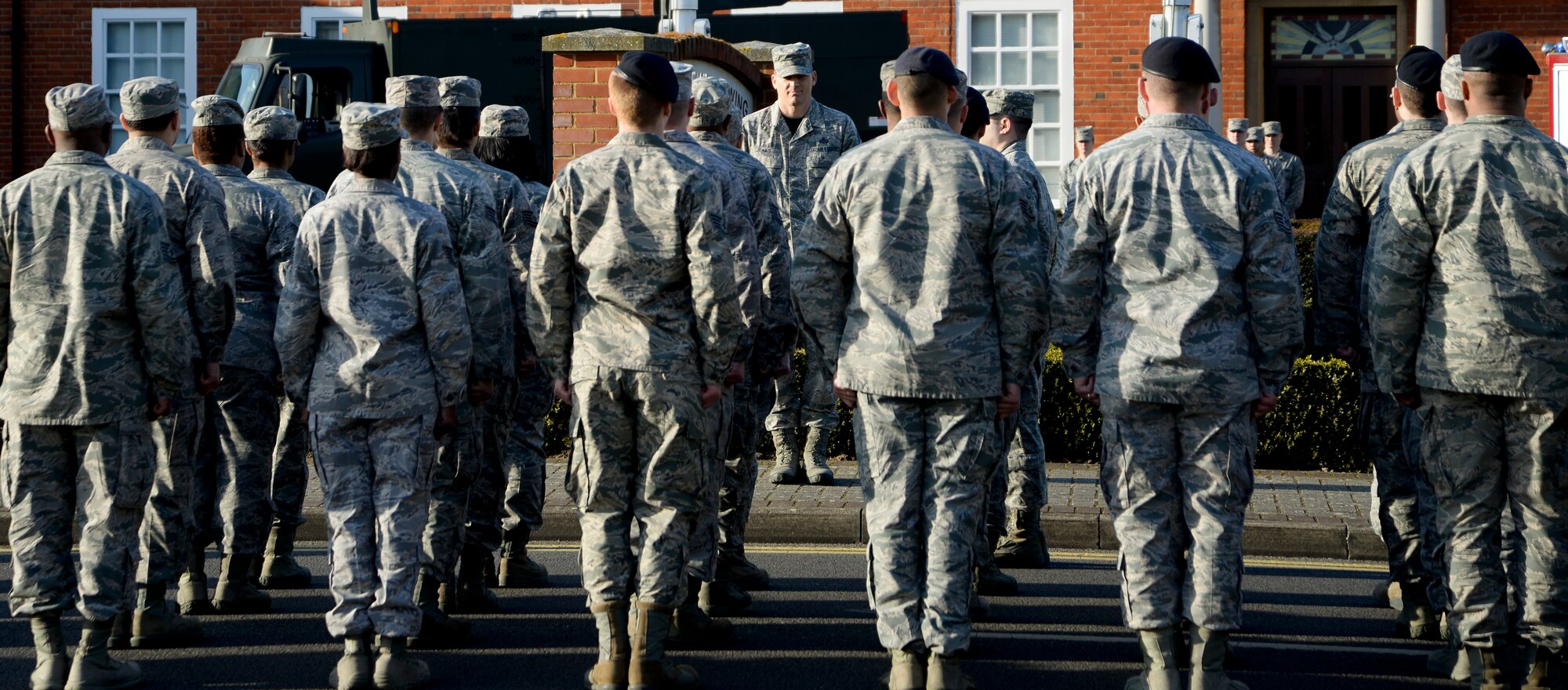 Members of Team Mildenhall stand in formation waiting for a retreat ceremony to begin March 27, 2015, at RAF Mildenhall, England. The ceremony was held in honor of Chief Master Sgt. Tracy Jones, 100th Air Refueling Wing command chief, as he prepares to retire from active duty. (U.S. Air Force photo by Senior Airman Victoria H. Taylor/Released)