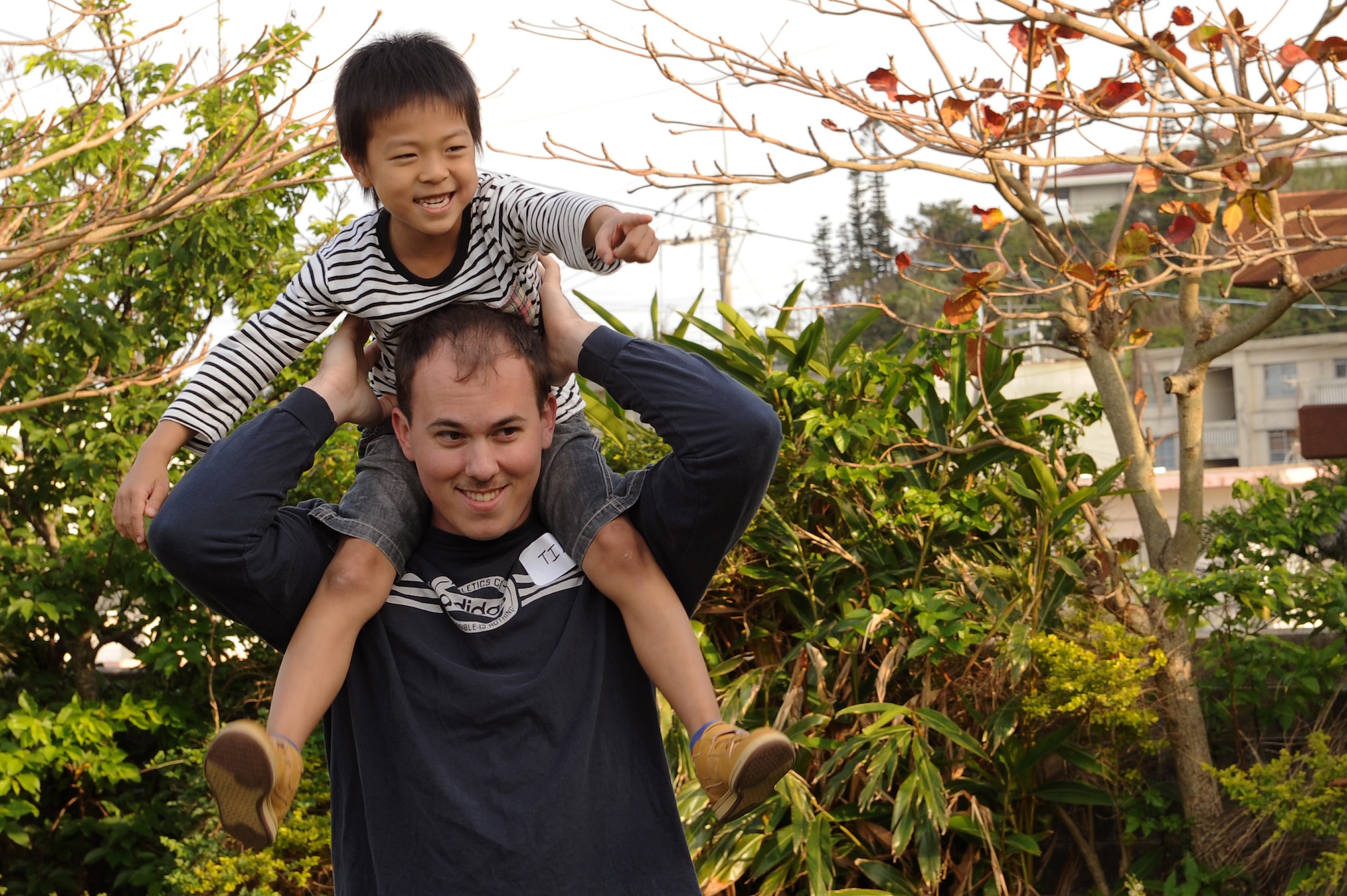 U.S. Air Force Senior Airman Timothy Dupke, Wisconsin Air National Guard 115th Fighter Wing ordnance technician, carries a child from the Midori School-Age Program on his shoulders in Okinawa City, Japan, March 26, 2015. Dupke and other Airmen from the group organized several games and Easter-themed activities for the children to play in an effort to interact with the local community during their time on island. (U.S. Air Force photo by Airman 1st Class Zade C. Vadnais)