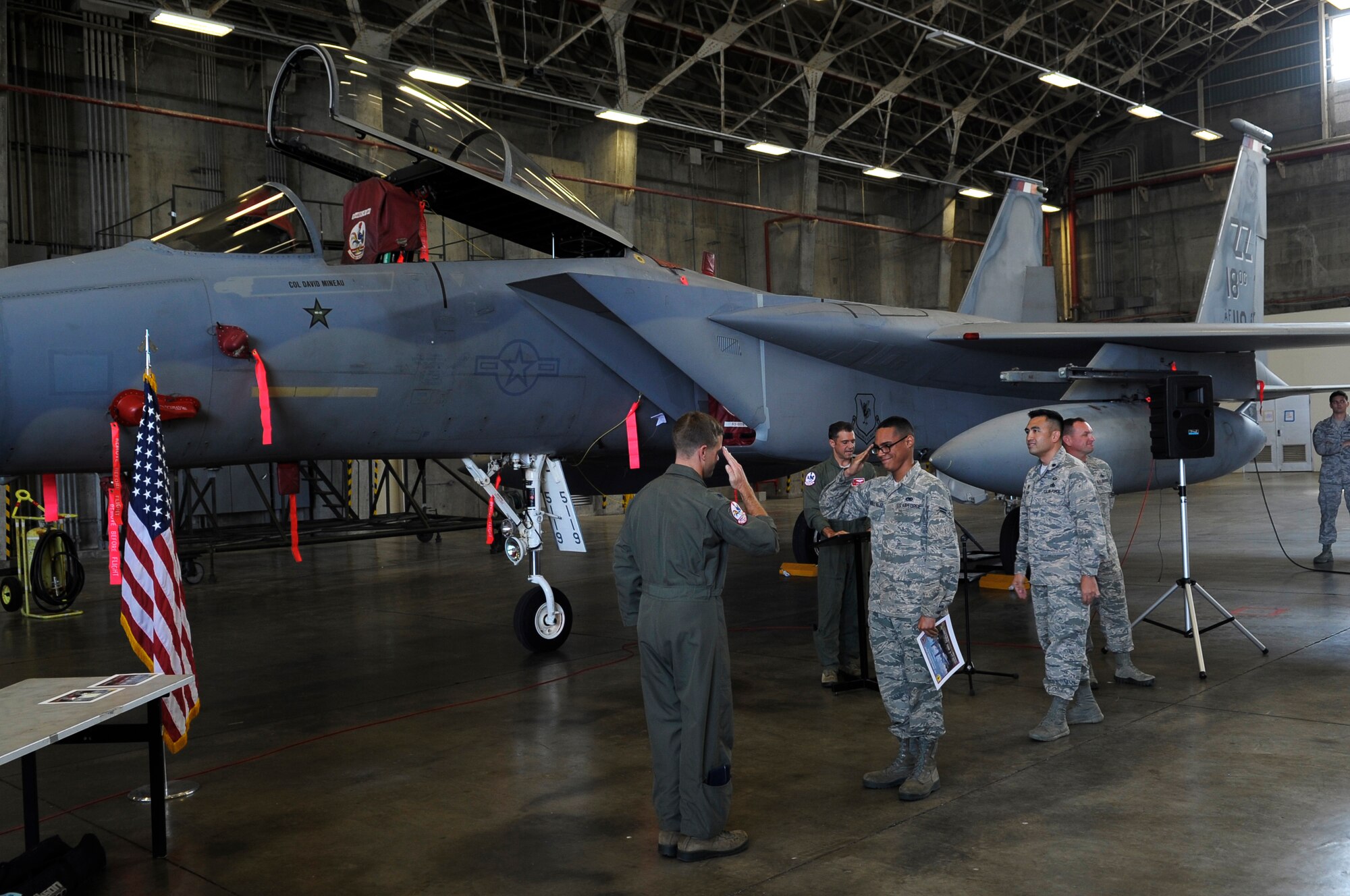 U.S. Air Force Airman 1st Class Adyel Quinones-Velez, 67th Aircraft Maintenance Unit dedicated crew chief, salutes Lt. Col. William Denham, 67th Fighter Squadron commander, after receiving his certificate and coin at the Dedicated Crew Chief Ceremony March 31, 2015 at Kadena Air Base, Japan. He was awarded the honor of dedicated crew chief for demonstrating superior performance in compliance with safety practices and technical requirements while displaying managerial skills and leadership abilities. (U.S. Air Force photo by Airman 1st Class Zackary A. Henry)
