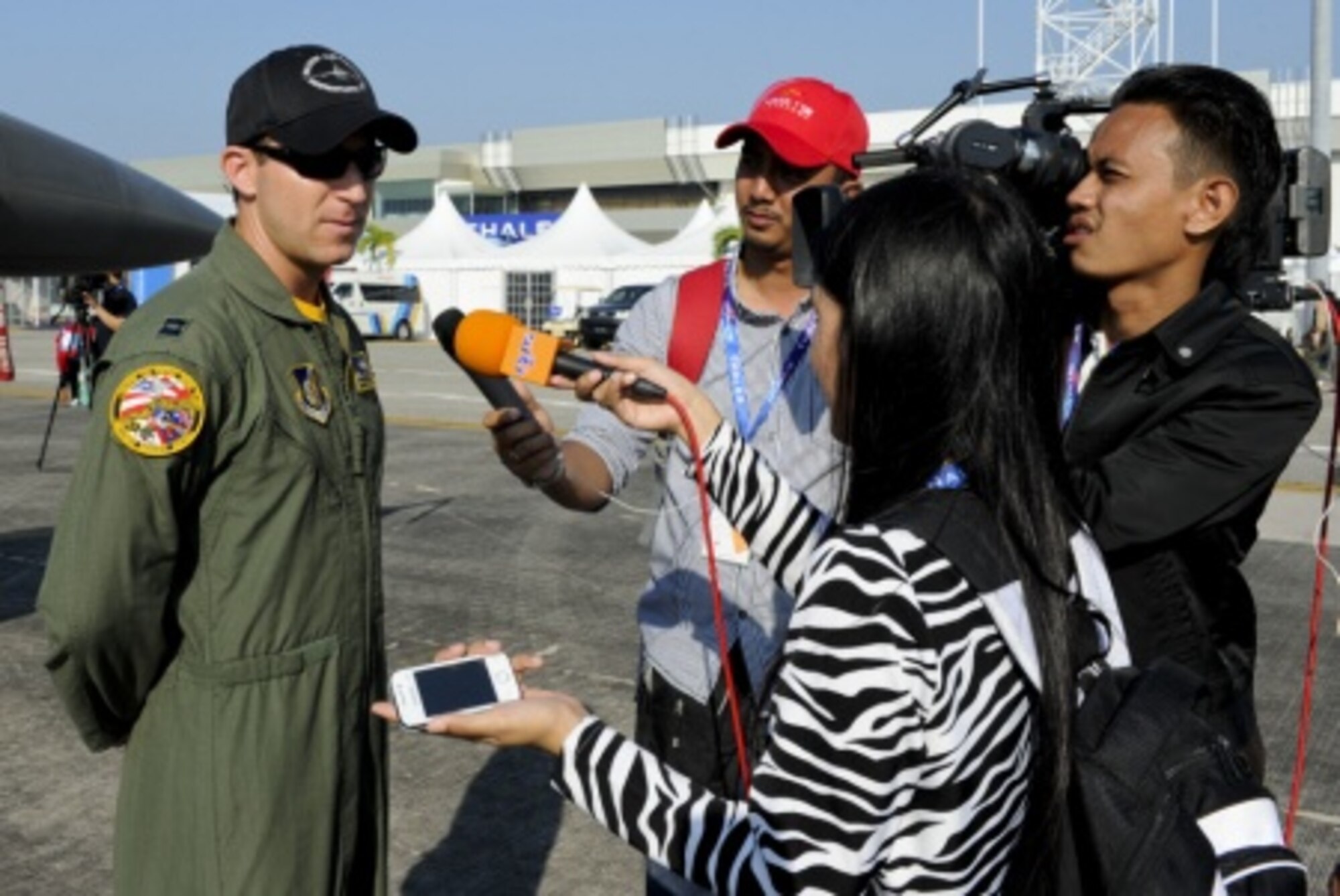 Capt. Austin Brown, a Pacific Air Forces’ F-16 Demonstration Team pilot, answers a question during an interview for RTM Chanel 1 on the flightline at Langkawi International Airport, Malaysia, March 17, 2015. The U.S. demonstration team joined more than 60 countries for the Langkawi International Maritime and Aerospace Exhibition ‘15. Participating in the LIMA ‘15 airshow demonstrates the U.S. Air Force’s dedication to strengthening relations with Malaysia. (U.S. Air Force photo by Tech. Sgt. Terri Paden/RELEASED)