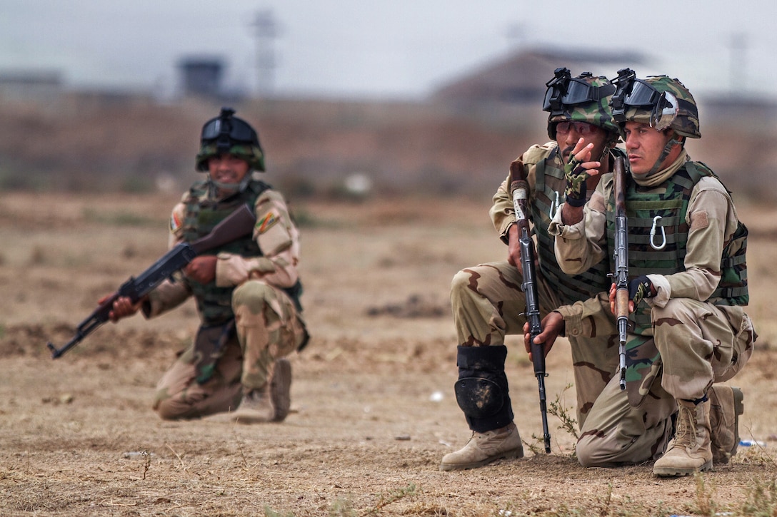 An Iraqi army team leader discusses the best way to approach a road during a training exercise on Camp Taji, Iraq, March 24, 2015. The Iraqi soldiers rehearsed moving safely through roads and other areas where they might be exposed to enemy fire.