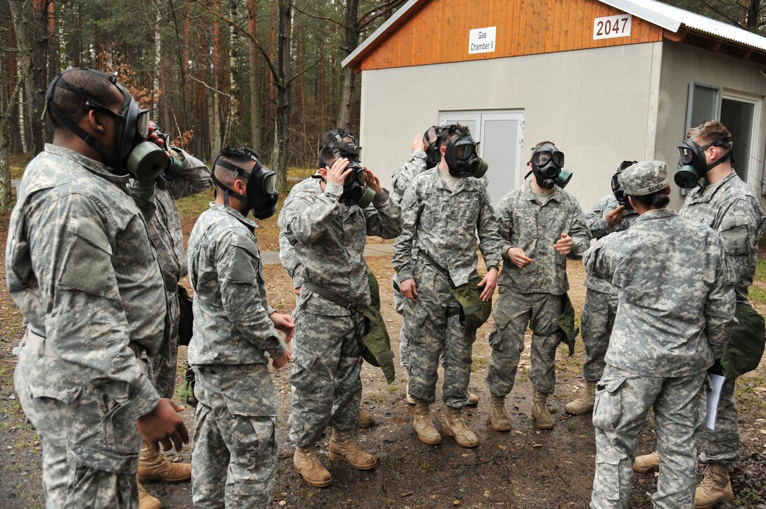 U.S. Army paratroopers check their protective masks before entering the