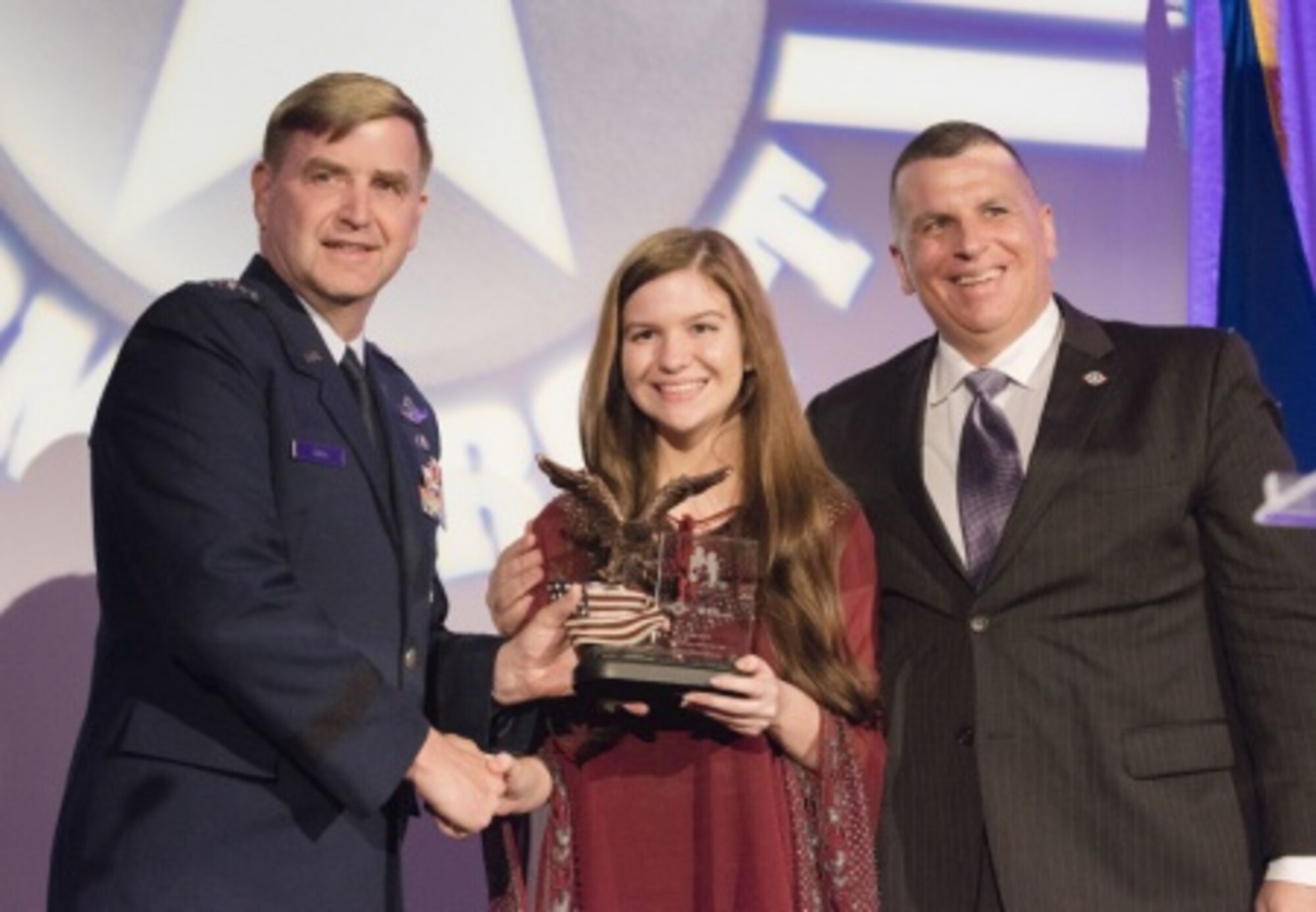 Lt. Gen. Stephen L. Hoog, Assistant Vice Chief of Staff and Director of Air Staff at U.S. Air Force Headquarters, and Operation Homefront president Tim Farrell present Air Force Child of the Year nominee Sarah Francesca Hesterman with a trophy during the 2015 Military Child of the Year Awards Gala, in Arlington, Va., April 16, 2015. The awards gala is held to recognize outstanding military children - one nominated for each of the service branches. (DoD photo by Army Staff Sgt. Sean K. Harp/Released)