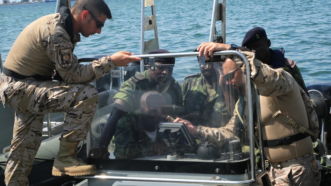 Spanish Marines review navigation equipment with Angolan Marines in Luanda, Angola, March 4, 2015, before conducting coxswain training in the Luanda Harbor. The Spanish Marines worked with the Angolan coxswains on seafaring capabilities. U.S. Marines, British Royal Marines and Spanish Marines spent three days training with the Angolans in close-quarters combat, small boat operations and repair, and search and seizure techniques before departing for Cameroon during the maritime security exercise, Africa Partnership Station. (Official U.S. Marine Corps photo by Staff Sgt. Steve Cushman/Released)