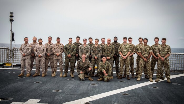 Spanish, U.S. and British Royal Marines pose for a group photo aboard the USNS Spearhead, March 22, 2015. This multinational group of Marines spent three months traveling to four different African countries working with the militaries of Ghana, Angola, Cameroon and Gabon on basic infantry skills, marksmanship, small-boat operations and search and seizure techniques. (U.S. Navy photo by Petty Officer 2nd Class Kenan O'Connor/Released)