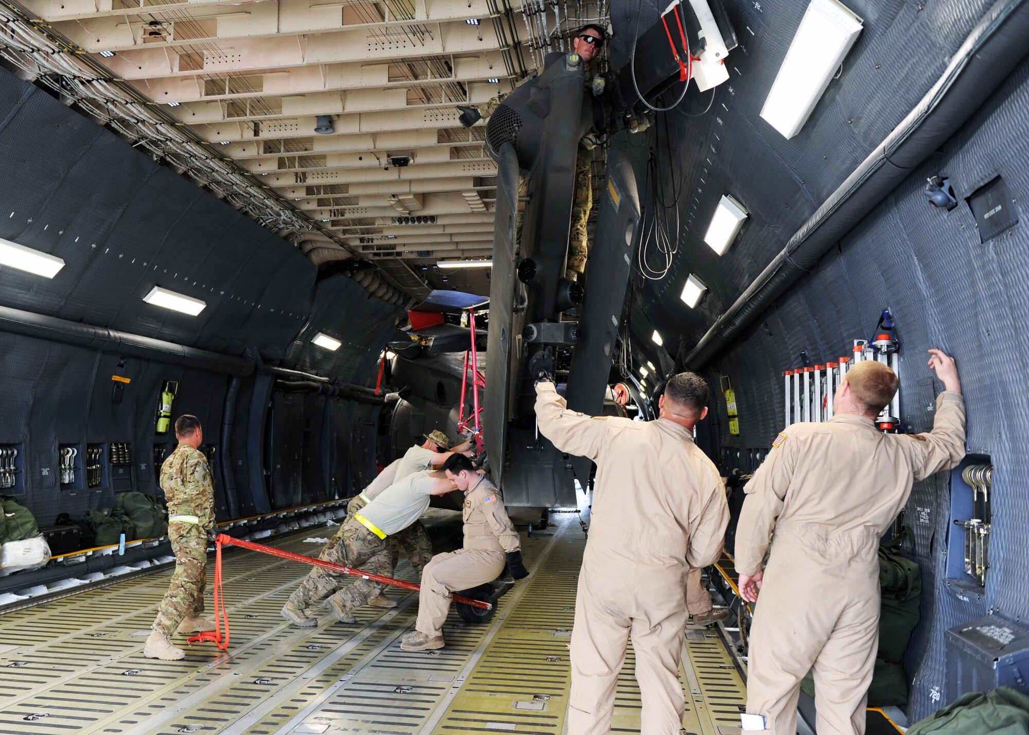 U.S. Soldiers assigned to the 96th Aviation Support Battalion, 101st Combat Aviation Brigade, and Airmen assigned to the 9th Airlift Squadron from Dover Air Force Base, Del., work together to spot and position an Army UH-60 Black Hawk helicopter during an upload onto a C-5 Super Galaxy aircraft April 26, 2015 at Bagram Airfield, Afghanistan. Throughout April, several helicopters were uploaded and transported to the United States to facilitate the swap out of the Army’s 82nd and 101st Combat Aviation Brigades. (U.S. Air Force photo by Staff Sgt. Whitney Amstutz/Released)