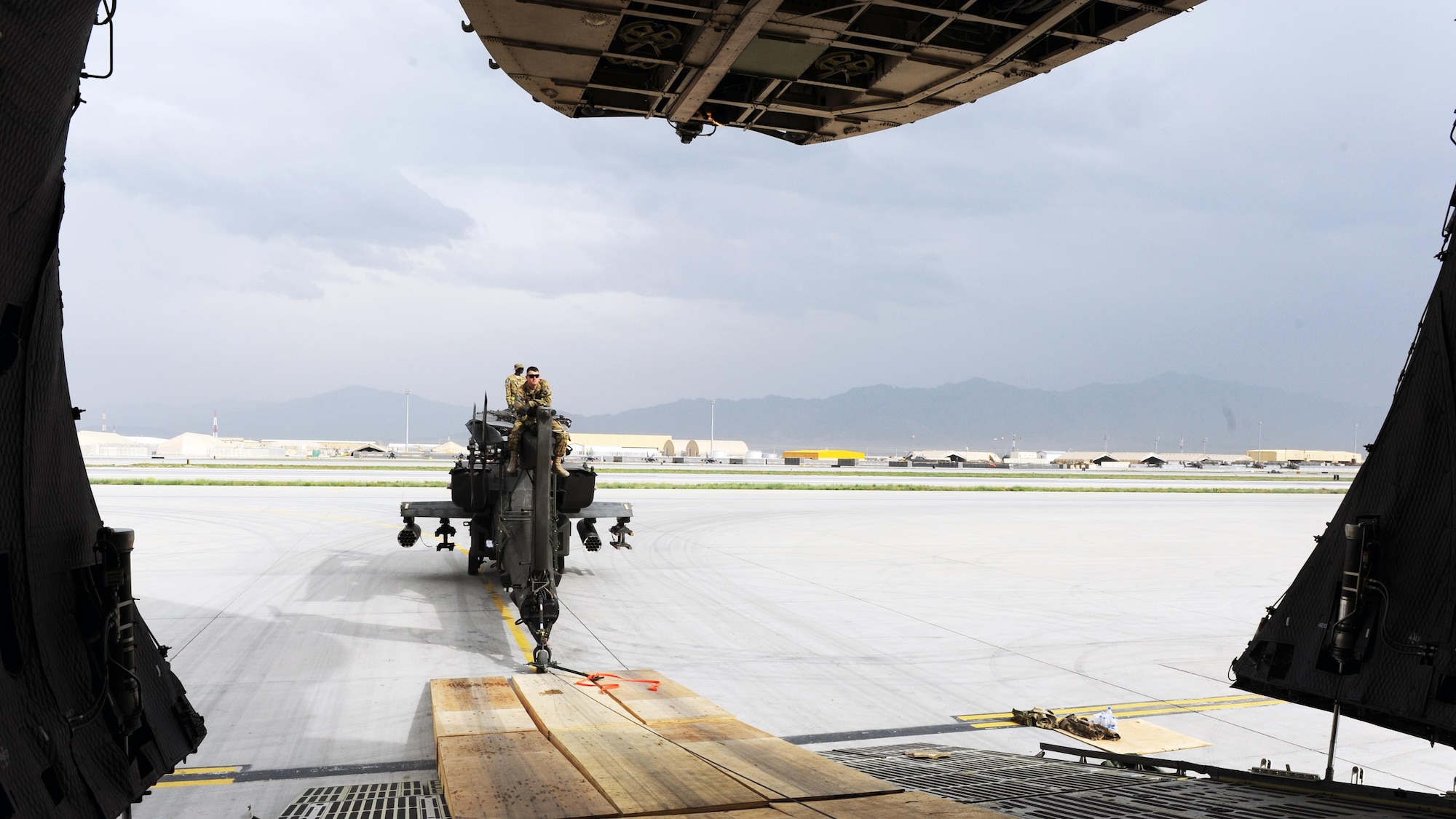 U.S. Soldiers assigned to the 96th Aviation Support Battalion, 101st Combat Aviation Brigade, act as spotters during the upload of a U.S. Army AH-64 Apache helicopter onto an Air Force C-5 Super Galaxy aircraft April 26, 2015 at Bagram Airfield, Afghanistan. Throughout April, several helicopters were uploaded and transported to the United States to facilitate the swap out of the Army’s 82nd and 101st Combat Aviation Brigades. (U.S. Air Force photo by Staff Sgt. Whitney Amstutz/Released)
