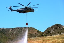 A CH-53E Super Stallion with Marine Heavy Helicopter Squadron 466, 3rd Marine Aircraft Wing, drops water in a mock fire area during an aerial firefighting exercise here, April 30. Aviation and ground units from Camp Pendleton, 3rd MAW, Navy Region Southwest, the California Department of Forestry and Fire Protection, and the San Diego Sheriff’s Department participated in the annual exercise, which provides ready, trained and certified military and civilian resources to combat wild land fires in the region.