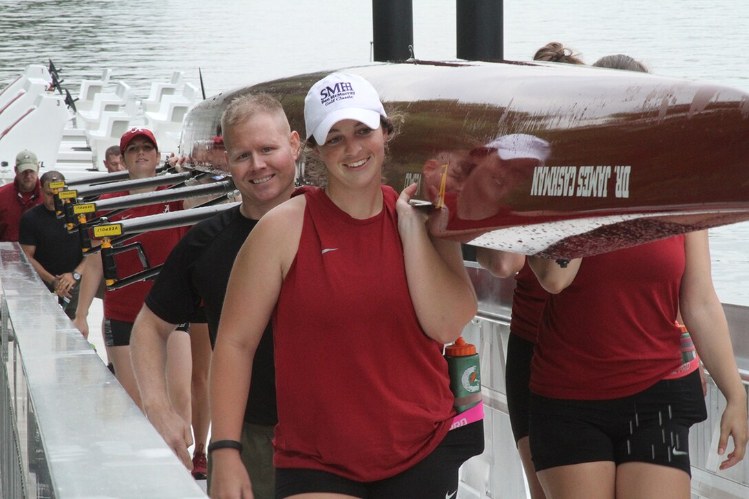 Maj. Michael Hays, the commanding officer of Marine Corps Recruiting Station Montgomery, helps carry one of the team's boats back after the teams training Tuesday, April 28, 2015, in Tuscaloosa, Ala. Hays was one of several Marines who visited the team that day to recognize Ashley Allison, a Marine officer applicant who is working toward being a pilot.
