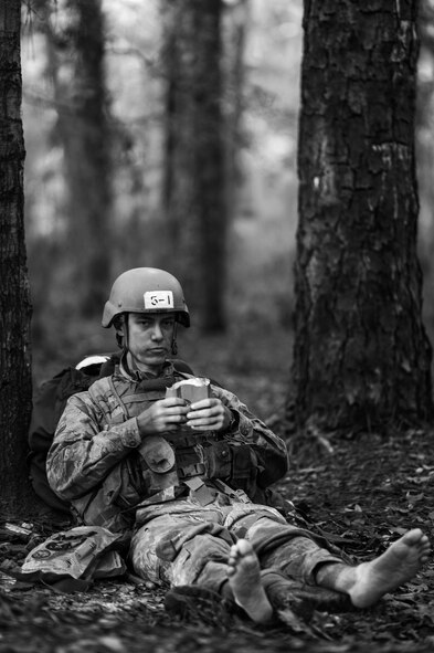 A Tactical Air Control Party candidate from Falcon 98 eats an MRE during a field training exercise at Eglin Range, Fla., March 24, 2015. TAC-P candidates from Falcon 98 are the last class to graduate from Hurlburt Field, Fla., before the schoolhouse moves to Lackland Air Force Base, Texas. (U.S.  Air Force photo/Senior Airman Christopher Callaway)