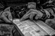 A Tactical Air Control Party candidate from Falcon 98 reads his map during a field training exercise at Eglin Range, Fla., March 24, 2015. TAC-P candidates from Falcon 98 are the last class to graduate from Hurlburt Field, Fla., before the schoolhouse moves to Lackland Air Force Base, Texas. (U.S.  Air Force photo/Senior Airman Christopher Callaway)