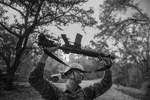A Tactical Air Control Party candidate from Falcon 98 lifts his weapon over his head during a field training exercise at Eglin Range, Fla., March 24, 2015. TAC-P candidates from Falcon 98 are the last class to graduate from Hurlburt Field, Fla., before the schoolhouse moves to Lackland Air Force Base, Texas. (U.S.  Air Force photo/Senior Airman Christopher Callaway)
