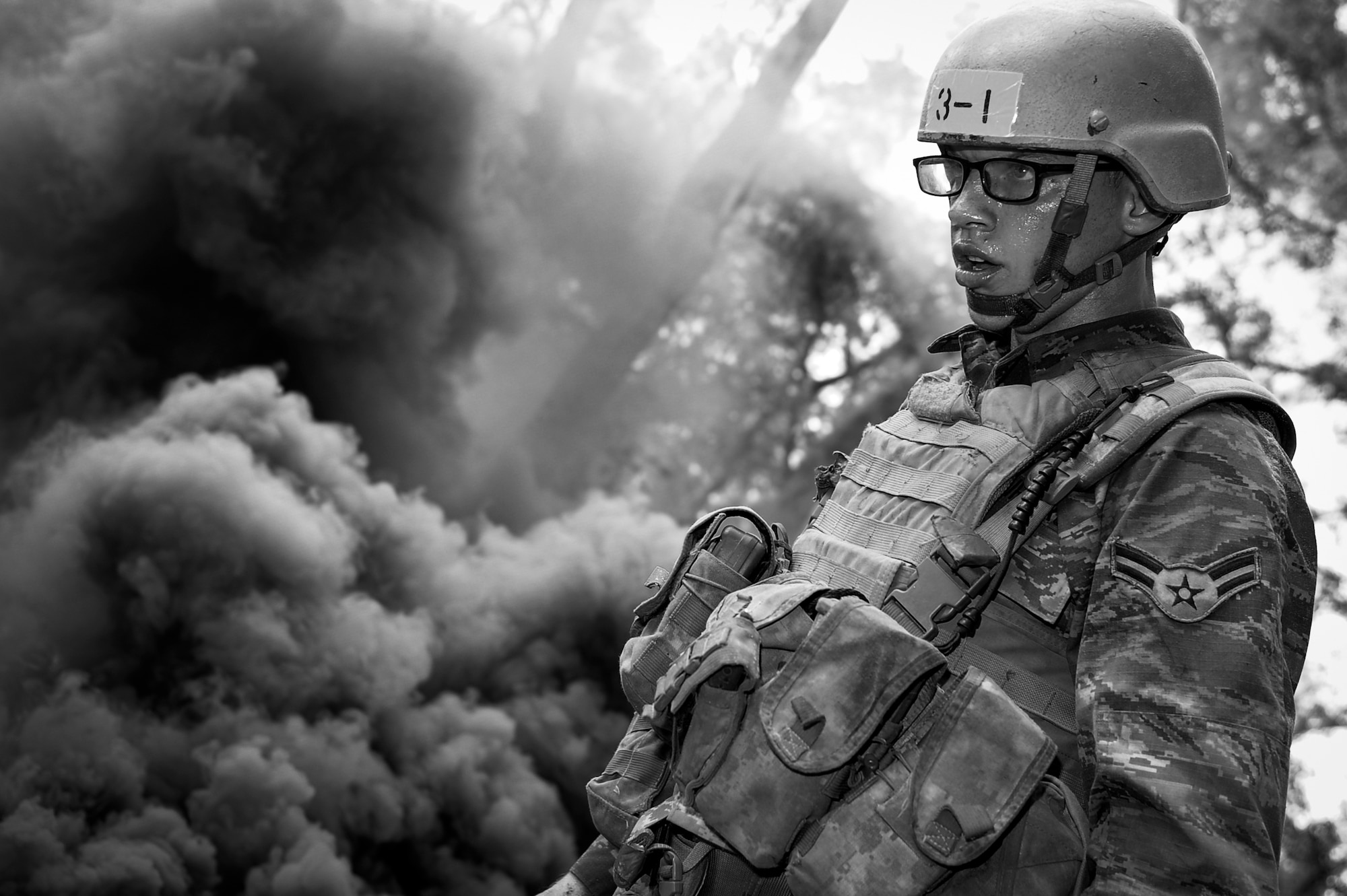 Jacob Hughes, a Tactical Air Control Party candidate from Falcon 98, looks over his gear after a training smoke grenade detonated near his position during training at Eglin Range, Fla., March 24, 2015. TAC-P candidates from Falcon 98 are the last class to graduate from Hurlburt Field, Fla., before the schoolhouse moves to Lackland Air Force Base, Texas. (U.S.  Air Force photo/Senior Airman Christopher Callaway)