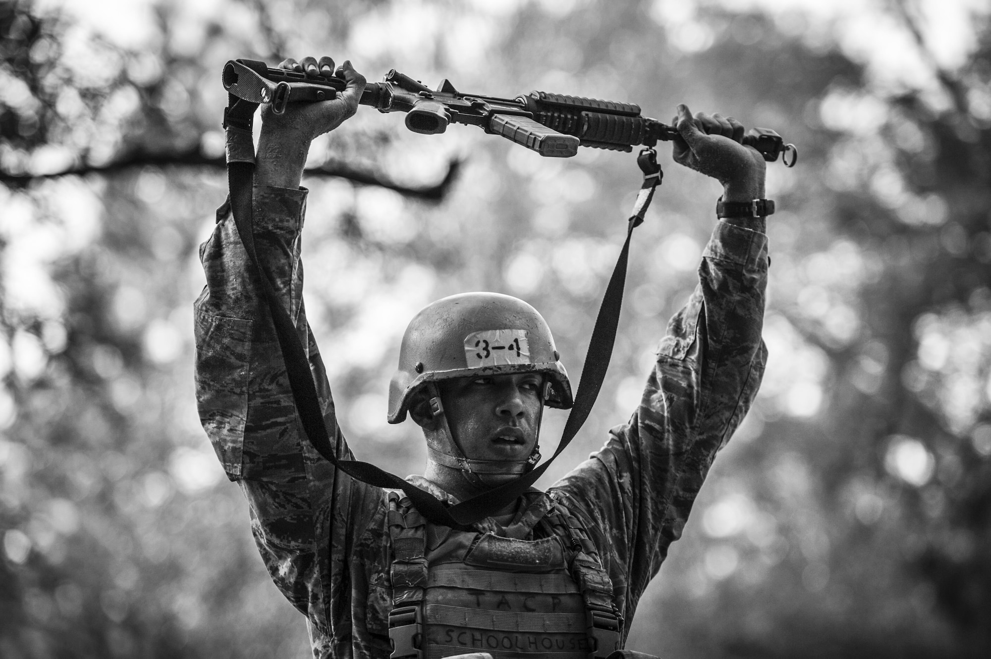 A Tactical Air Control Party candidate from Falcon 98 lifts his weapon over his head during a field training exercise at Eglin Range, Fla., March 24, 2015. TAC-P candidates from Falcon 98 are the last class to graduate from Hurlburt Field, Fla., before the schoolhouse moves to Lackland Air Force Base, Texas. (U.S.  Air Force photo/Senior Airman Christopher Callaway)