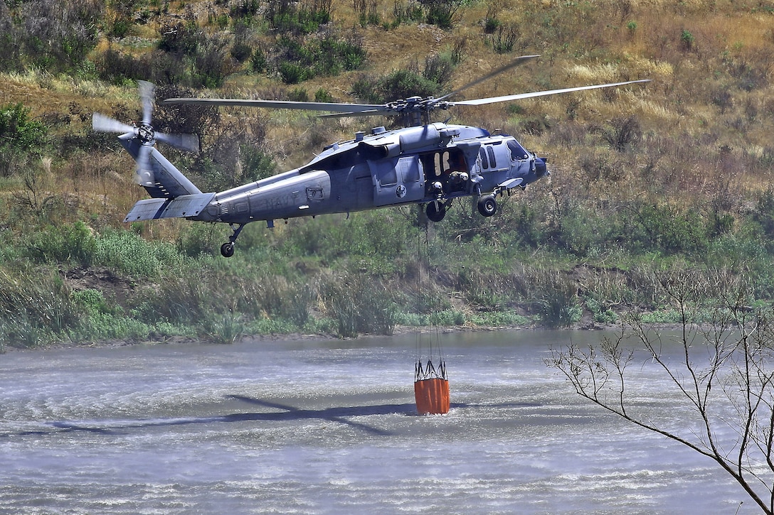 An MH-60 extracting water in a mock fire area during an aerial firefighting exercise at Las Pulgas Lake here, April 30. Aviation and ground units from Camp Pendleton, 3rd MAW, Navy Region Southwest, the California Department of Forestry and Fire Protection, and the San Diego Sheriff’s Department participated in the annual exercise, which provides ready, trained and certified military and civilian resources to combat wild land fires in the region. (Photo by Cpl. Shaltiel Dominguez)