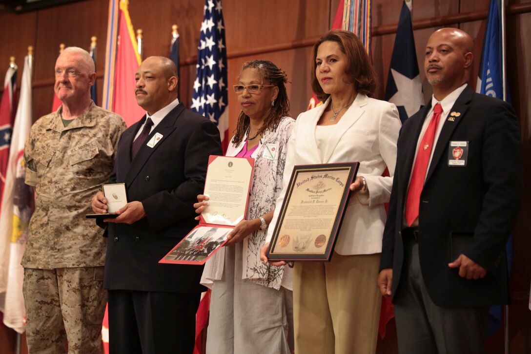 NEW ORLEANS – Lt. Gen. Richard P. Mills (left), commander of Marine Forces Reserve, Frederick D. Turner III (left), Frederick D. Turner’s son, Leah Turner (center), Frederick D. Turner’s daughter, Kathleen Turner (right), Frederick D. Turner’s daughter, and Ronald Johnson, President of the Grainville Alexander Montford Point Chapter, pose for a photo with Frederick D. Turner’s Congressional Gold Medal and awards at Marine Corps Support Facility New Orleans, April 30, 2015. Frederick D. Turner posthumously received the Congressional Gold Medal, awarded to all Montford Point Marines. Many Montford Point Marines were leaders in the American civil rights movement. Their legacy in the Marine Corps engineered social and cultural changes which created a lasting impact and has greatly contributed to the success of the Marine Corps today. (U.S Marine Corps photo by Lance Cpl. Ian Ferro)
