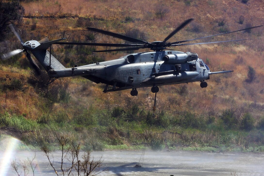 An CH-53 extracts water in a mock fire area during an aerial firefighting exercise at Las Pulgas Lake here, April 30. Aviation and ground units from Camp Pendleton, 3rd MAW, Navy Region Southwest, the California Department of Forestry and Fire Protection, and the San Diego Sheriff’s Department participated in the annual exercise, which provides ready, trained and certified military and civilian resources to combat wild land fires in the region. (Photo by Cpl. Shaltiel Dominguez) 

