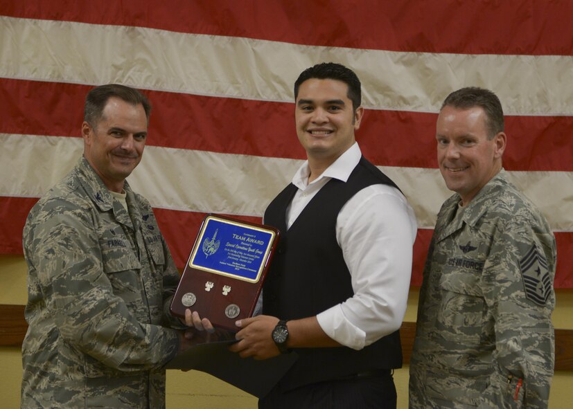 Col. Sean Farrell, 1st Special Operations Wing commander and Chief Master Sgt. Cory Olson, 1st SOW command chief, presents the Special Operations Youth Group the team Angel Award at the Soundside Club on Hurlburt Field, Fla., April 29, 2015. The Angel Award is a prestigious award that was established in 1988 by Mrs. Eunice Welch, wife of retired Air Force Chief of Staff Gen. Larry D. Welch. (U.S. Air Force photo/Senior Airman Christopher Callaway)