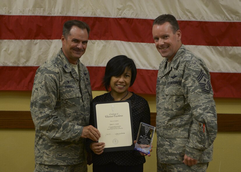 Col. Sean Farrell, 1st Special Operations Wing commander and Chief Master Sgt. Cory Olson, 1st SOW command chief, present Jane Leon, the Volunteer Excellence Award at the Soundside Club on Hurlburt Field, Fla., April 29, 2015. The Volunteer Excellence Award reflects a volunteer’s leadership, initiative and dedication, as well as, recognizes life-long volunteerism of Air Force family members, retirees and civilians. (U.S. Air Force photo/Senior Airman Christopher Callaway)