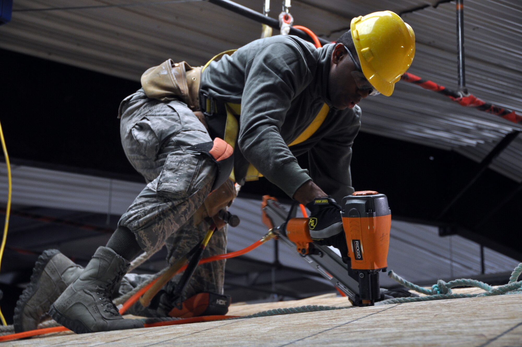Staff Sgt. Jason Yallery, a structures specialist with 911th Airlift Wings’ Civil Engineer Squadron, uses a nail-gun to complete construction of the sub-roof of a home that the crew is building for locals of the Navajo Nation in the area around Gallup, N.M., April 21. (U.S. Air Force Photo by Senior Airman Joseph E. Bridge)