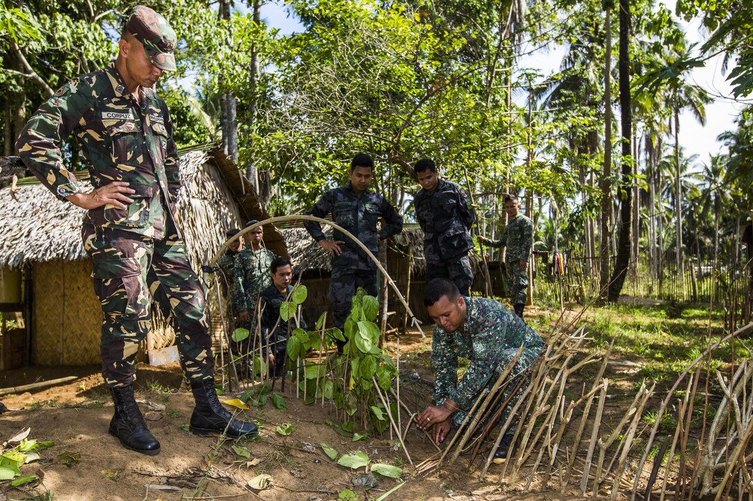 Philippine Marine Corps Cpl. Jose Ryan Tinio, a combat medic with Battalion Landing Team 4, 3rd Marine Brigade, shows military members participating in Jungle Survival training how to utilize a trap in Puerto Princesa, Philippines, during exercise Balikatan 2015, April 28. The Jungle Survival training, taught by the Philippine Marine Corps, was held to instruct military members as well as practice techniques to become more effective when responding to crisis in the region.