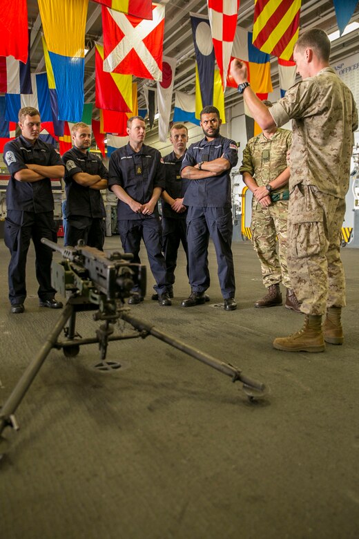 U.S. Marine Corps Lance Cpl. Charlie Wheeler, right, a motor transportation operator with the 22nd Marine Expeditionary Unit (MEU), gives a presentation on the M2 .50 caliber machine gun to British Royal Navy sailors with the HMS Lancaster during a tour aboard the amphibious assault ship USS Wasp (LHD 1) while out at sea April 30, 2015. Marines and U.S. Navy Sailors with the 22nd MEU from Marine Corps Base Camp Lejeune, N.C., participated in Navy Week 2015 in New Orleans April 23-29 and Fleet Week Port Everglades, Fla., May 4-10. The purpose of Navy Week was to showcase the strength and capabilities of the Navy-Marine Corps team through tours, static displays and community relations events, providing the public the opportunity to meet and interact with Marines and Sailors. (U.S. Marine Corps photo by Sgt. James R. Smith/Released)