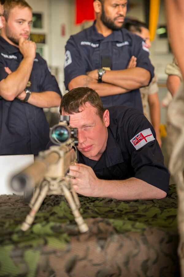 British Royal Navy Petty Officer Marine Engineer Elliott Watson, refrigeration engineer with the HMS Lancaster, looks through the scope of an M40A5 sniper rifle during a tour aboard the amphibious assault ship USS Wasp (LHD 1) while out at sea April 30, 2015. U.S. Marines and U.S. Navy Sailors with the 22nd Marine Expeditionary Unit from Marine Corps Base Camp Lejeune, N.C., participated in Navy Week 2015 in New Orleans April 23-29 and Fleet Week Port Everglades, Fla., May 4-10. The purpose of Navy Week was to showcase the strength and capabilities of the Navy-Marine Corps team through tours, static displays and community relations events, providing the public the opportunity to meet and interact with Marines and Sailors. (U.S. Marine Corps photo by Sgt. James R. Smith/Released)