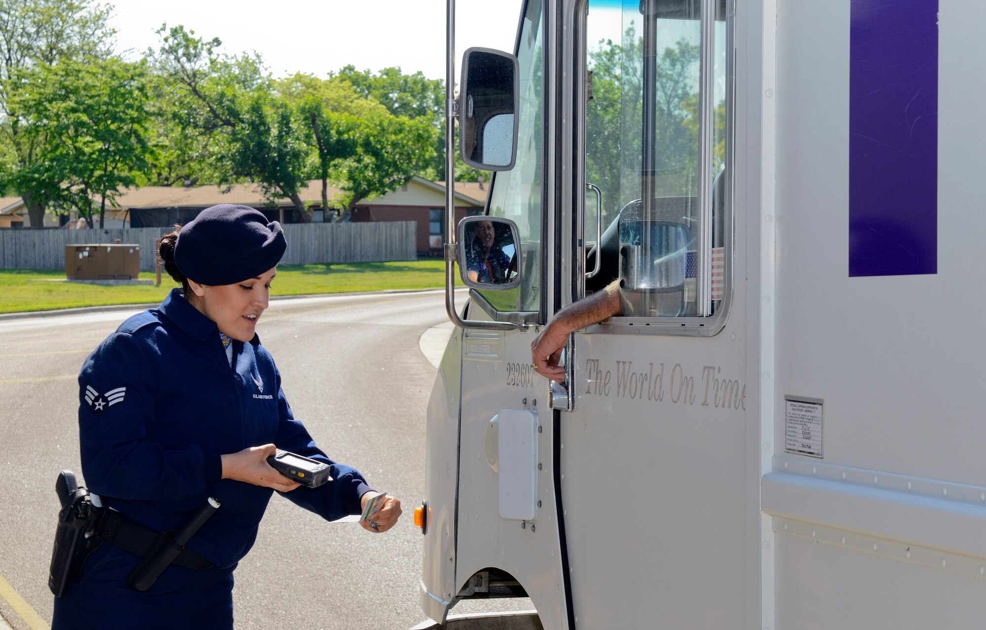 Senior Airman Shanise Trejo, 22nd Security Forces Squadron entry controller, checks the base pass of a contractor, May, 1, 2015, at McConnell Air Force Base Kan. The primary duty of an entry controller is to verify the ID of anyone who drives onto base. They are the first line of defense for military installations. (U.S. Air Force photo by Senior Airman Colby L. Hardin)